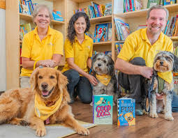 A high-resolution thumbnail for a California dog adoption blog featuring a happy family hugging a newly adopted Goldendoodle in a sunlit California park. The image includes bold, professional text overlays reading 